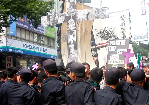 가로막힌 십자가 경찰이 '기도모임' 참석자들의 평화행진을 저지하고 있다. 